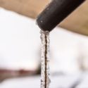 Close-up of a pipe with clear water flowing, relevant to Bud's Plumbing & Repair Service.