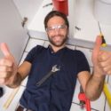 Man with glasses giving thumbs up on floor surrounded by plumbing tools at Bud's Plumbing & Repair Service.