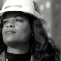 A woman in a hard hat looks confidently upward, representing skilled plumbing services by Bud's Plumbing & Repair Service.