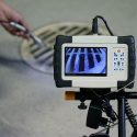 Inspection camera examining drainage system with display screen and controls, part of Bud's Plumbing & Repair Service.