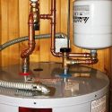 Water heater with copper piping and temperature controls for plumbing maintenance by Bud's Plumbing & Repair Service.