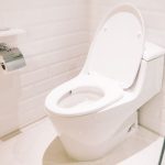 Modern toilet in a clean, tiled bathroom, showcasing a sleek minimalist design by Bud's Plumbing & Repair Service.